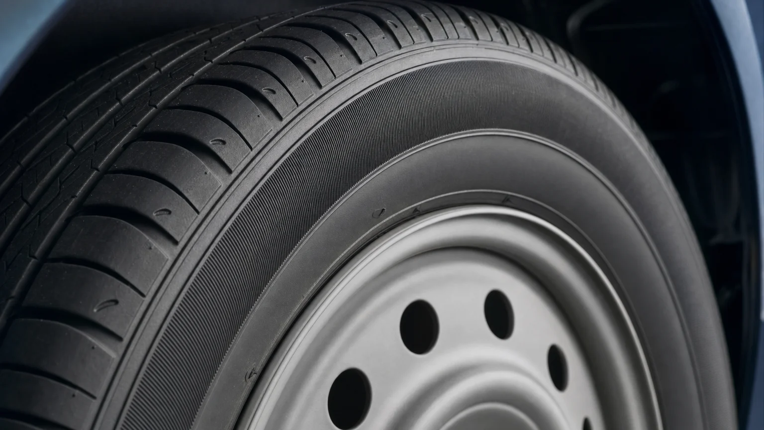 Close-up of an intact, unbranded vehicle tire showing its tread and sidewall.