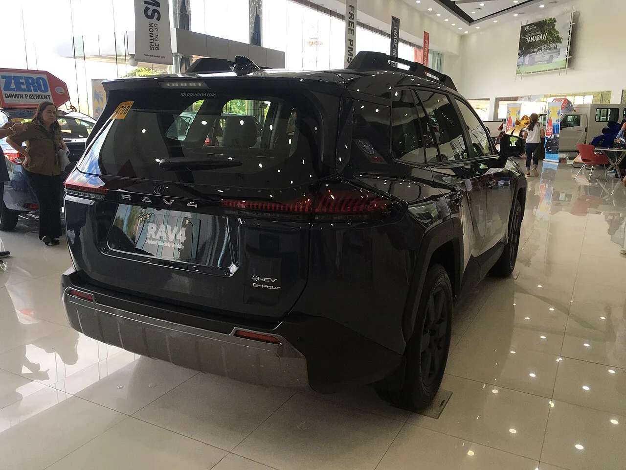 Rear and side of a 2026 Toyota RAV4 Woodland hybrid in a showroom